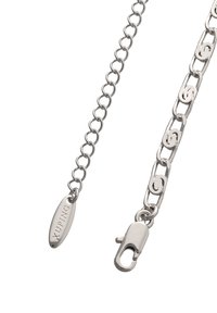 Sølvkæde med ovale led og dekorative detaljer. Har en lås og et mærke med brandnavn. Glat tekstur, poleret finish.