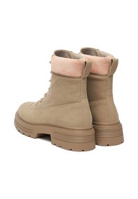 Bocanci de gleznă din suede bej cu un guler din suede roz, talpă groasă din cauciuc bej și sistem de șireturi în față. Prezintă detalii de cusătură pe laterale.