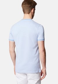 Jasnoniebieski bawełniany t-shirt z krótkim rękawem i prążkowanym okrągłym dekoltem. Posiada subtelne teksturowane wykończenie oraz kontrastowe niebieskie akcenty.