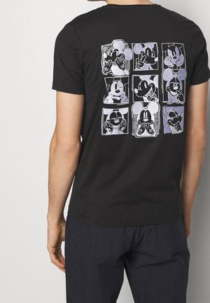 T-shirt noir présentant neuf visages stylisés de Mickey Mouse affichant diverses expressions ludiques, disposés en grille 3x3 au dos.