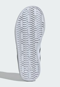 Witte sneakersol met een golvend loopvlakpatroon en een getextureerd oppervlak. Bevat een reliëf merklogo en gebogen randen voor grip.