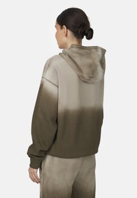 Hoodie vert olive avec un effet dégradé, doté d'une capuche à cordon, de manches longues et d'une coupe décontractée. Matériau doux avec une texture lisse.