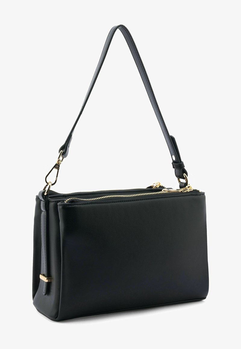 Sac à main en cuir noir avec deux compartiments zippés et une seule anse d'épaule ornée de ferrures dorées.