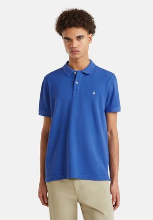 Blauwe polo gemaakt van katoen met een zachte textuur, korte mouwen, een twee knoopsluiting en een klein geborduurd logo op de borst.