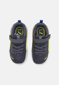 Baskets en maille gris foncé avec des accents jaunes et bleus. Équipées d'une sangle ajustable, d'un dessus texturé et de semelles blanches. Logo visible sur les côtés.