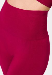 High-waisted leggings in fuchsia, gemaakt van een rekbare, gladde stof. Beschikt over een geribbeld ingezet en een naadloos ontwerp voor comfort.