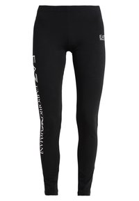 Svarta leggings med en figurnära design, tillverkade av elastiskt tyg. Har vit varumärkespåtryckning längs sidan och en logotyp vid midjan.