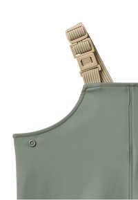 Groene, waterbestendige stoffen overalls met een brede halslijn, verstelbare beige band en drukknoopdetails op de schouder.