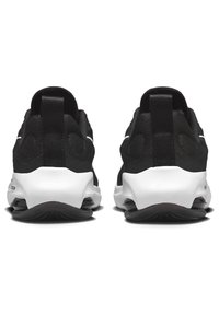 Schwarze Sportschuhe mit einem strukturierten Mesh-Obermaterial, weißen Akzenten, gepolsterten Sohlen und Zuglaschen an den Fersen für ein einfaches Anziehen.