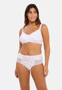 Ensemble de lingerie blanche comprenant un soutien-gorge à bordure en dentelle avec de délicats motifs floraux et une culotte taille haute avec des accents en dentelle.