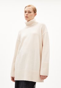 Lichtbeige coltrui gemaakt van zachte stof, met een geribde kraag en manchetten, in een oversized pasvorm en met verlaagde schoudernaad.