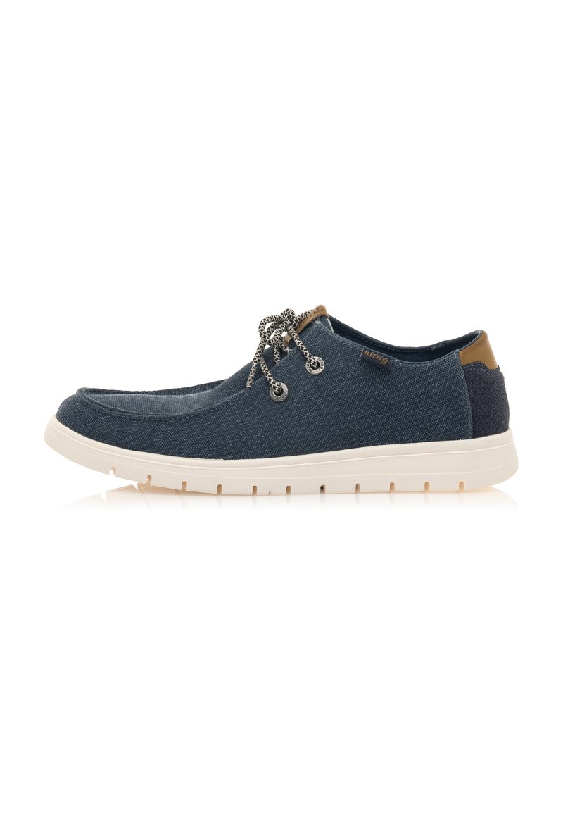 Zapatos casuales de lona azul marino con suelas de goma blanca, que cuentan con cordones decorativos y un acento marrón en el talón. Diseño plano.