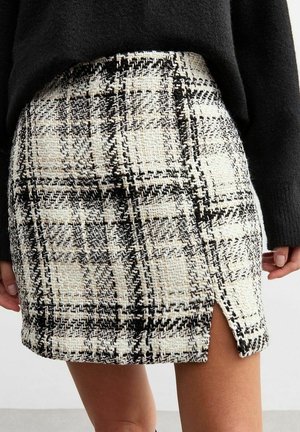 Tweed-mallinen minihame mustavalkoisella ruutukuvioinnilla, jossa on sivuhalkio ja teksturoidusta kankaasta. Sopii erinomaisesti kerrospukeutumiseen.