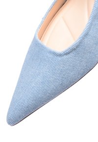 Scarpa con punta affusolata realizzata in tessuto testurizzato azzurro chiaro, con un interno liscio e un design a bassa scollatura che mette in evidenza la zona delle dita.