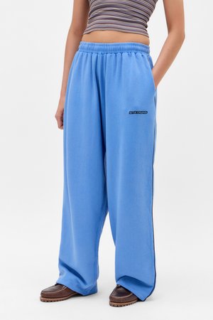 Pantaloni da jogging azzurri chiari, larghi, con una vita elasticizzata e tasche laterali. Presentano un piccolo logo nero sull'anca sinistra.
