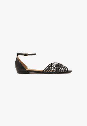 Black flat sandals with a woven design, leather material, ankle strap with adjustable buckle, and a natural tan insole.