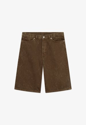 Pruunid teksapüksid, millel on tekstuuriga viimistlus, viis taskut, vööaasad ja nööbiliist. Omaduseks pehmed kulumismustrid ja lai sääre disain.