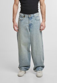 Jeans a gamba larga in denim azzurro chiaro con un effetto lavato, dotati di chiusura a bottone, cinque tasche e una vestibilità comoda in vita e lungo le gambe.