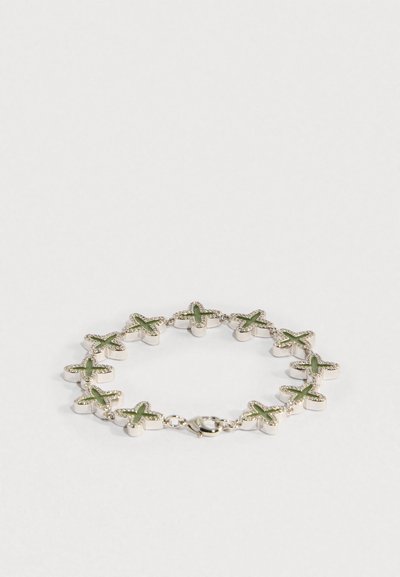 Pulseira com cruzes ligadas em prata com centros em esmalte verde e pequenos cristais ao redor, fechada com fecho de lagosta.