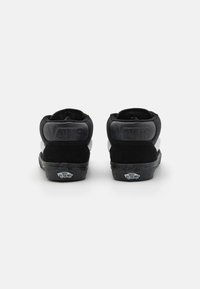 Sneakers nere alte in materiali scamosciati e tessili, con collo imbottito, logo in rilievo sul tallone e suola in gomma.
