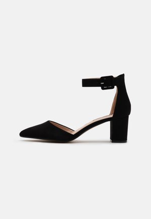Czarne zamszowe szpilki z migdałowym noskiem, paskiem w kostce z klamrą oraz średnim obcasem blokowym. Gładka faktura o minimalistycznym designie.