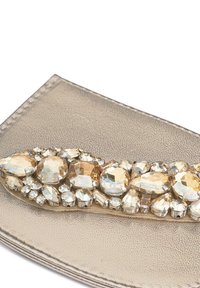 Bolso metálico dorado con un acabado texturizado, que presenta un destacado adorno de piedras claras y ámbar en diversas formas y tamaños.