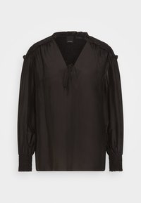 Blouse noire à manches longues en tissu lisse avec un col en V, un lien ajustable et des détails froncés aux épaules et aux poignets.