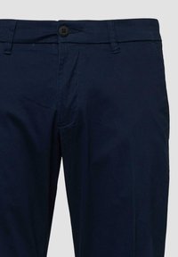 Námornícky modré nohavice s upraveným strihom, s tlačidlom na zapínanie, pútkami na opasok a rovnými nohavicami na jednofarebnom pozadí.