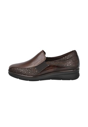 Zapato marrón tipo slip-on con lados texturizados, panel elástico para ajuste y suela acolchada negra, mostrado desde el lado exterior sobre fondo blanco.