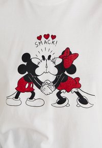 White t-shirt featuring a graphic of two cartoon mice kissing, with red glitter accents, positioned on a white background. Text above reads "SMACK!"