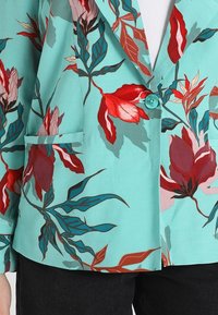 Kwiatowa marynarka z turkusową bazą, zdobiona czerwoną i różową grafiką kwiatową, z jednym przednim kieszeniem i pasującym turkusowym guzikiem.