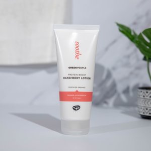 Protein-Boost Hand/Body Lotion in a white tube; orange accent at the base. Text includes "soothe," "Green People," and ingredients, quinoa, and calendula.