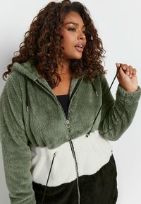 Fleece zip hoodie i grön, vit och svart. Har en huva med dragsko, dragkedjestängning och en texturerad tyg med mjuk finish.