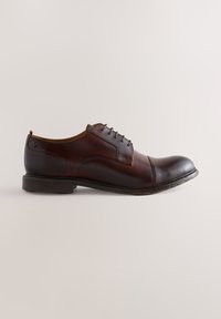 Bruine leren Oxford-schoen met een gladde afwerking, ronde neus, veterontwerp en een lage gelaagde hak. Subtiele stikdetails aan de zijkanten.
