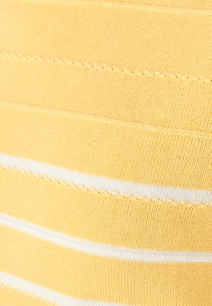 Primo piano di tessuto lavorato a maglia giallo con strisce orizzontali bianche e motivi di punti vari che creano sottili linee strutturate.