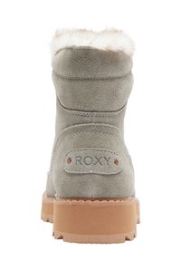 Grijze suede laars met nepbontvoering aan de bovenkant, rubberen zool en "ROXY" logo op de hak. Heeft stiknaaddetails en een afgeronde vorm.