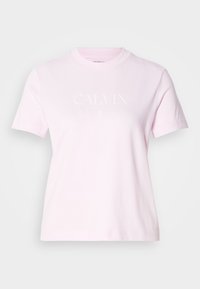 Lyserød bomulds T-shirt med korte ærmer, rund halsudskæring og et hvidt trykt logo med teksten "CALVIN KLEIN" over brystet.