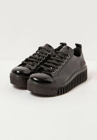 Zapatillas de plataforma negras de cuero con puntera redonda, suela texturizada y diseño de cordones. Las características incluyen un acabado suave y un detalle de marca sutil.