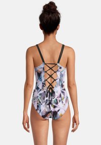 Eéndelige zwempak met een veelkleurig geometrisch patroon; heeft een verstelbaar crisscross rugontwerp en dunne zwarte schouderbandjes.