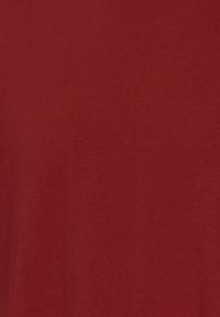 Red cotton fabric featuring a smooth texture with a solid color, no visible patterns or accents. Simple, unembellished design.
