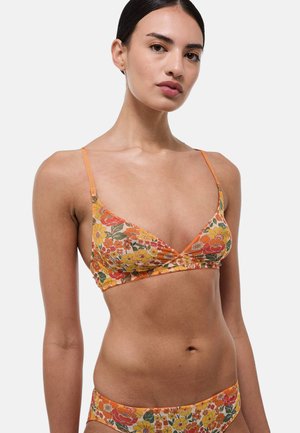 Bralette fleuri en orange, avec un décolleté en V et des bretelles réglables. Le matériau présente un motif de fleurs colorées sur l'ensemble du tissu.