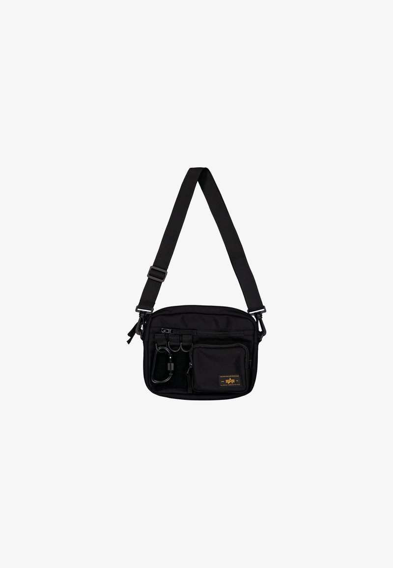 Μαύρη νάιλον τσάντα ώμου με ρυθμιζόμενο λουράκι, πολλαπλές τσέπες με φερμουάρ και μεταλλικές λεπτομέρειες. Διαθέτει λογότυπο μπροστά και υφή στην επιφάνειά της.