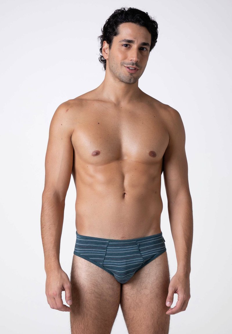 Costumi da bagno a slip blu e grigi a righe, realizzati in tessuto elastico, con un design a vita bassa e una texture liscia.