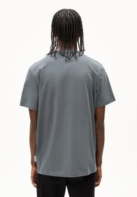 Grijze katoenen t-shirt met korte mouwen, ronde hals en een ontspannen pasvorm; heeft een klein merklabel op de zijnaad.