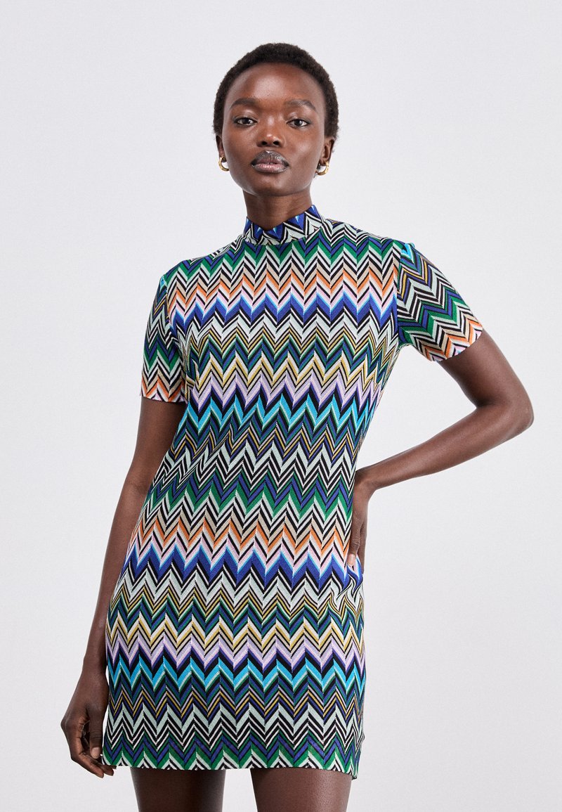Abito mini a maniche corte con motivo zigzag multicolore in verde, blu e arancione, con colletto alto e design aderente.