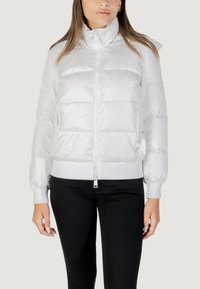 Giacca a vento bianca con chiusura a zip, polsini e cintura a coste. Presenta un cappuccio e un design trapuntato orizzontale per l'isolamento.