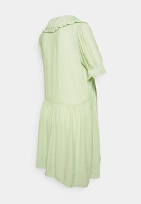 Vestido verde claro, de mangas curtas, com colarinho frisado e saia em camadas, feito de tecido texturizado, apresentando um caimento solto e suave.