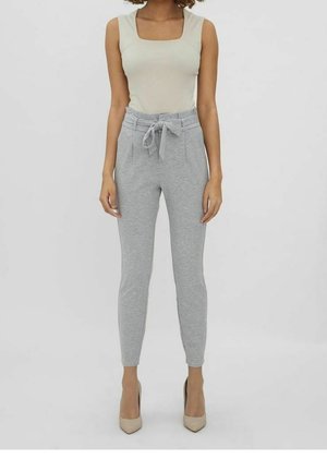 Pantalons de jogging gris clair au design épuré, avec une taille élastique et des poches avant. Assortis à un haut sans manches beige et des talons beiges.