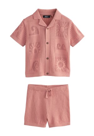 Pink strikket kortærmet skjorte med knapper og mønstre af sol og bølger, kombineret med matchende pink strikkede shorts med snøre i taljen.