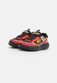 Las zapatillas Skechers en rojo y negro presentan una punta redondeada, suela gruesa, vibrantes adhesivos de carreras, diseño de ajuste con cordones y una etiqueta de tira a cuadros.